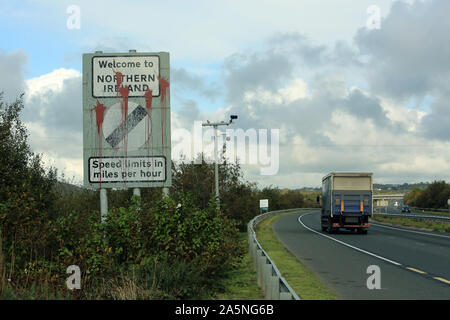 A road sign welcoming covered in paint welcomes motorist into Northern Ireland on the border between Northern Ireland and Ireland, on October 21, 2019 on the border between Newry in Northern Ireland and Dundalk in the Irish Republic. Boris Johnson has issued an eleventh-hour appeal to MPs to back his EU Withdrawal Agreement Bill, despite complaints from MPs that he is attempting to ram it through the Commons at high speed. MPs are beginning a three-day Brexit showdown - including two late-night sittings - in which the government's opponents will attempt to pass amendments on customs, a second Stock Photo