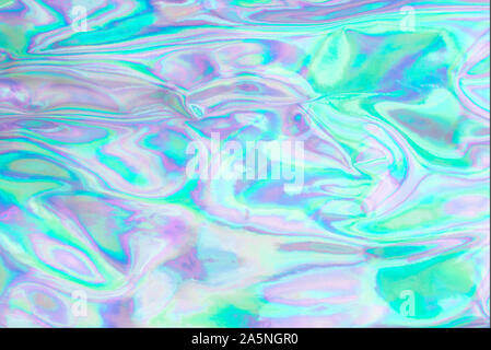Holographic wrinkled abstract foil texture. Glittering blurred surface pack. Multicolor bright holographic foil background. Stock Photo