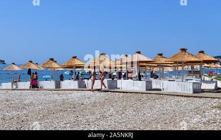 Budva, Montenegro - June 13.2019. City beach in the resort area with wooden umbrellas Stock Photo