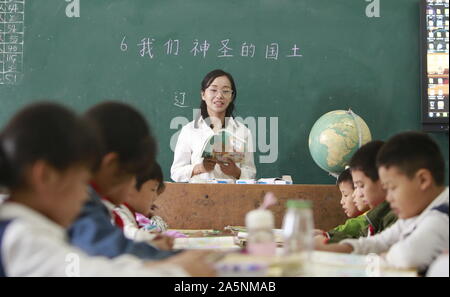 (191022) -- LUOTIAN, Oct. 22, 2019 (Xinhua) -- Fang Rong gives students a lecture at Hope primary School in Luotian County, central China's Hubei Province, Oct. 11, 2019. Fang Rong, 29, is the headmaster of Hope primary school of Luotian County, her alma mater. Born in a poverty-stricken region, Fang Rong was a left-behind girl. Thanks to the Hope Project and people's aids, she succeeded in graduating from a secondary normal school. To help more children and repay people's kindness, she decided to be a teacher at her alma mater. In spite of the austere way of life, Fang shouldered her res Stock Photo