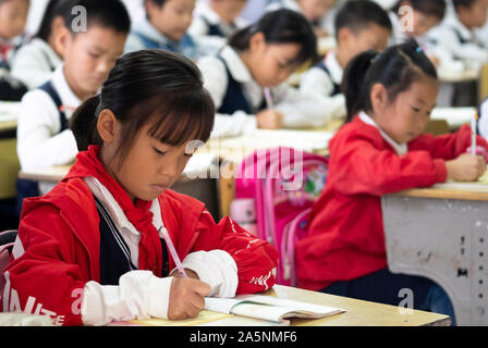 (191022) -- LUOTIAN, Oct. 22, 2019 (Xinhua) -- Students take a class at Hope primary School in Luotian County, central China's Hubei Province, Oct. 11, 2019. Fang Rong, 29, is the headmaster of Hope primary school of Luotian County, her alma mater. Born in a poverty-stricken region, Fang Rong was a left-behind girl. Thanks to the Hope Project and people's aids, she succeeded in graduating from a secondary normal school. To help more children and repay people's kindness, she decided to be a teacher at her alma mater. In spite of the austere way of life, Fang shouldered her responsibility f Stock Photo