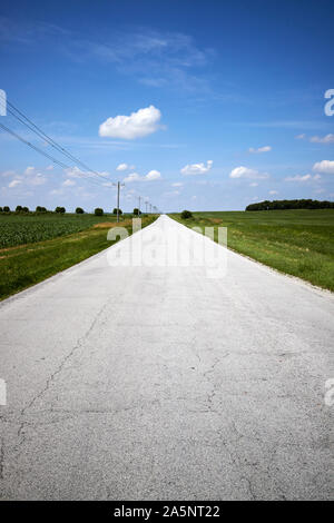 small local rural road through flat northern indiana farmland indiana USA Stock Photo