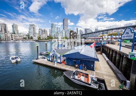 View of Ferry Dock at Granville Island with Vancouver Skyline in the back Stock Photo