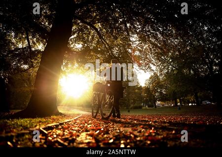 Hanover, Germany. 22nd Oct, 2019. Ruth from Hannover walks along the Maschteich with her bike in the early morning. Credit: Sina Schuldt/dpa/Alamy Live News Stock Photo