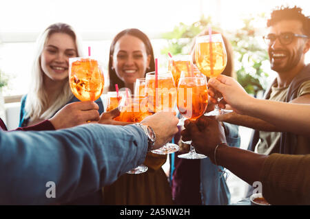 Group of happy friends drinking and toasting friends at a bar restaurant - Concept about young people having fun Stock Photo