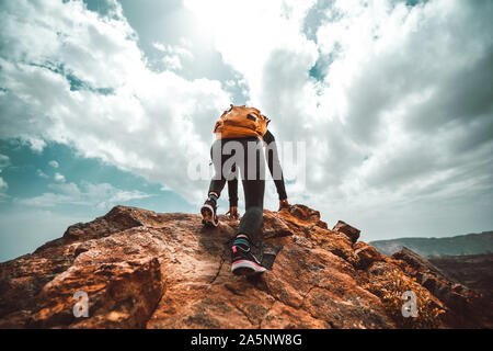 Success woman hiker hiking on sunrise mountain peak - Young woman with backpack rise to the mountain top. Discovery Travel Destination Concept Stock Photo