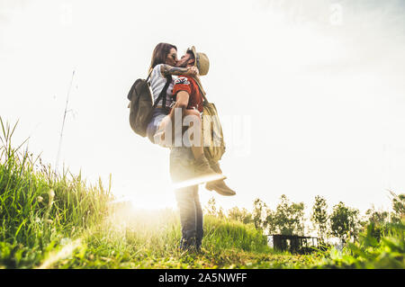Couple of lovers kissing outdoor at sunset in a field Stock Photo