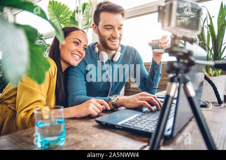Happy couple of bloggers recording a video preparing to post in social networks Stock Photo