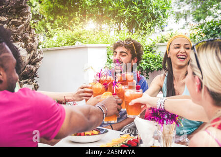 Happy friends having fun outdoor - Group of people toasting with cocktail at home party Stock Photo