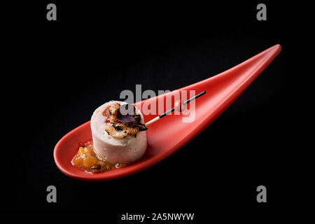 Goose liver pate, foie gras, served on black stone in Japanese red spoons. Paste served with jam and nuts. Fusion food concept, low key, copy space Stock Photo