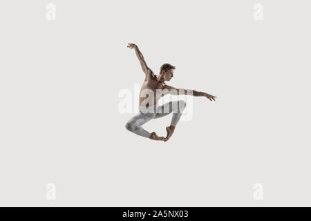 Modern ballet dancer. Contemporary art ballet. Young flexible athletic man.. Studio shot isolated on white background. Negative space. Stock Photo