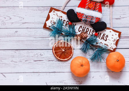 White wooden background with mandarines and Christmas deer on the table. Winter holiday frame. Flat lay top view. copy space Stock Photo