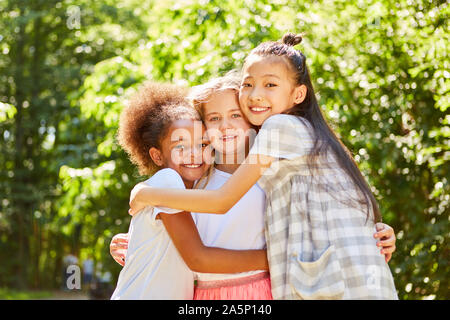 Three multicultural girls hugging each other as best friends Stock Photo