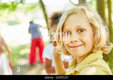 Blond boy in nature on a tour smiles happily Stock Photo