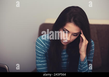 Unhappy woman with headache sitting near the laptop. Closeup portrait of business person on work. Hard day Stock Photo
