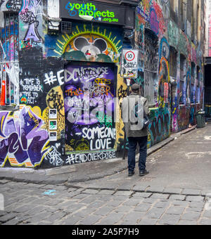 Man walking in Hosier Lane and Rutledge Laneway walls covered in graffiti and street art Melbourne Victoria Australia. Stock Photo