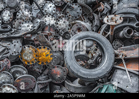 Close-up of old engine parts, nuts and bolts piled up for sale in a metal scrapyard. Stock Photo