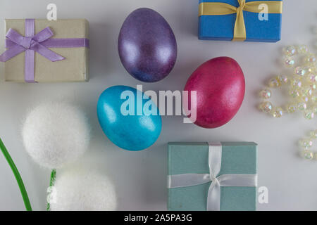 White Easter flat lay background with painted Easter eggs and gift boxes. Stock Photo