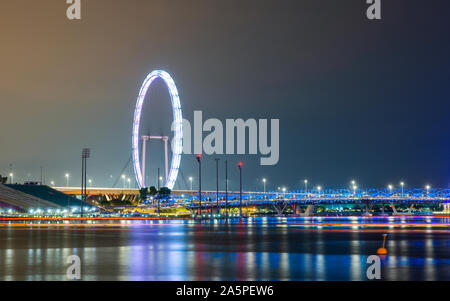 The Singapore Flyer and Helix Bridge at night Stock Photo