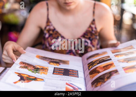 Young woman reading cookbook Stock Photo