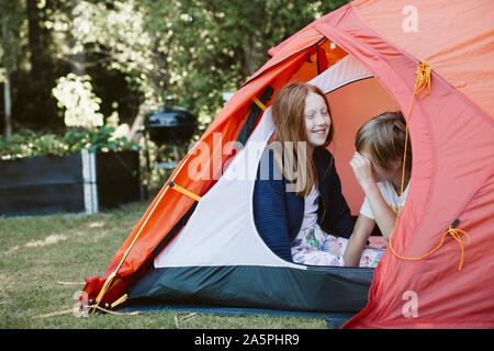 Brother and sister in tent in backyard Stock Photo