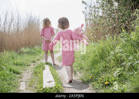 Two girls walking in meadow Stock Photo