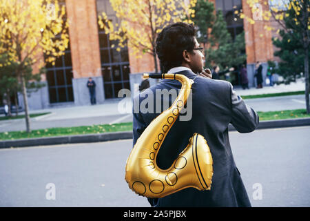 Funny handsome Indian man with a golden color inflatable tube Stock Photo