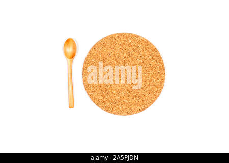 Top view of round stand under a plate or pan or glass with drink with wooden spoon . Made of cork. Isolated on white background. Stock Photo