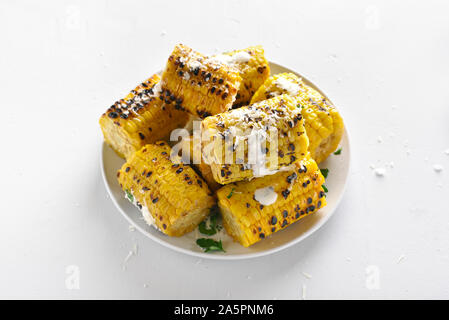 Grilled corn on cob with sauce and grated parmesan. Tasty vegetarian food Stock Photo