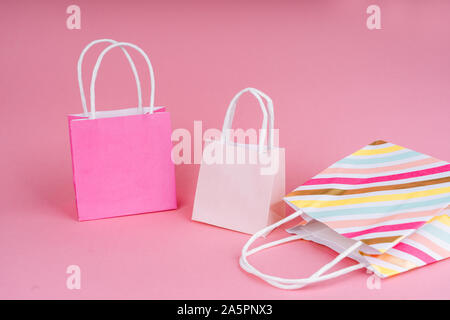 Paper shopping or gift bags on pink background with copy spaсe. Concept sales, shopping, black friday. Giving gift for birthday, christmas and New Yea Stock Photo