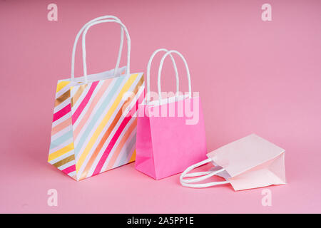 Paper shopping or gift bags on pink background with copy spaсe. Concept sales, shopping, black friday. Giving gift for birthday, christmas and New Yea Stock Photo