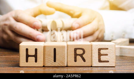 Wooden blocks with the word Hire. Headhunter selects a person from the crowd. Good choice. Human Resource Management. Recruiting Headhunting. Hiring e Stock Photo