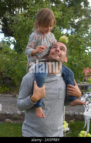 Man carrying daughter on shoulders Stock Photo