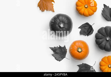 An autumn Halloween composition flat lay made with pumpkins and dry autumn leaves. Room for content and text. Stock Photo