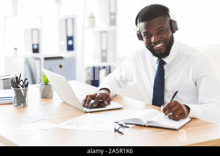 Happy black businessman learning foreign language online Stock Photo