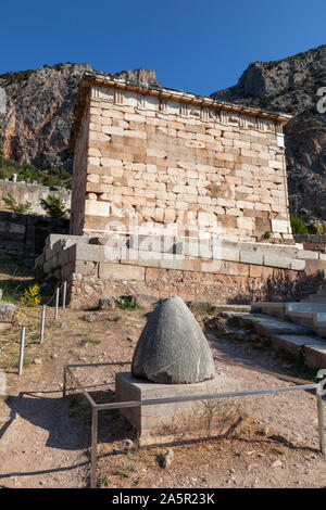 The omphalos stone or navel of the earth in front of The Treasury of the Athenians,Delphi, Greece Stock Photo