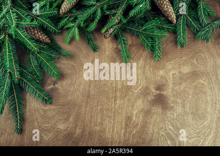 Christmas frame made with twigs and cones isolated on wooden background Stock Photo