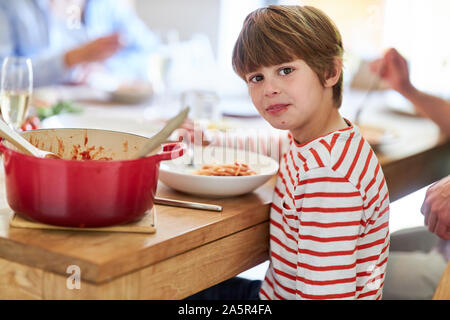 Boy eating spaghetti with family at the dining table at lunch Stock Photo