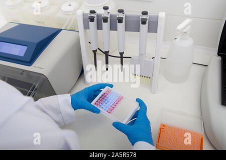 Hands of clinician holding small test tubes Stock Photo