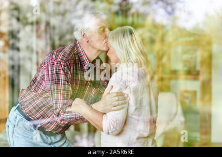 Senior gives his wife a kiss on the forehead as a sign of love and closeness