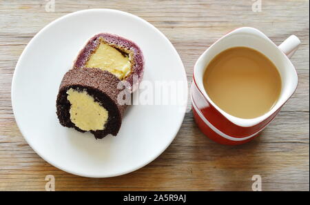 chocolate and grape cake roll filled cream eat couple with coffee in red cup Stock Photo