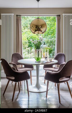 1960s style chairs at table in window of Victorian terrace renovation Stock Photo
