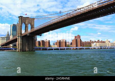 View from the East River in New York City, of the Manhattan end of the famous Brooklyn Bridge, which links the boroughs of Manhattan and Brooklyn. Stock Photo