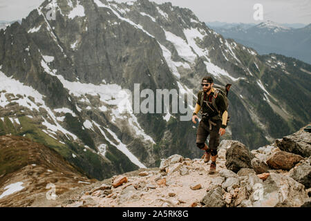 A male hiker walks along a trail in the North Cascades, Washington Stock Photo