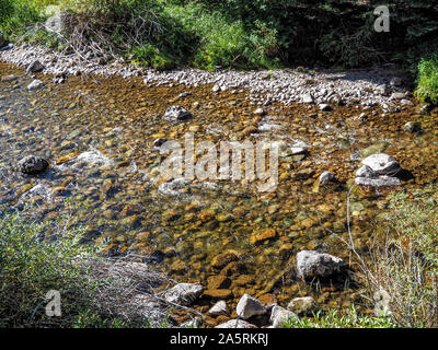 Clear water of mountain stream falling over river stones. Stock Photo