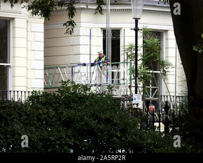 Builder erecting scaffolding outside a house in Notting Hill, London, UK. Stock Photo