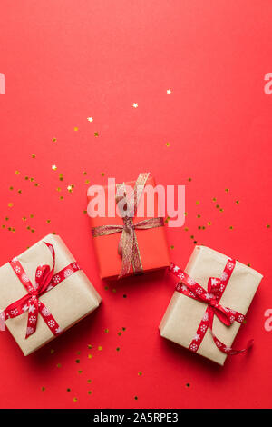 Bright in craft multicolor paper surprise boxes with gold shiny bow ribbons on a red background. Can use for birthday banner, story, birthday poster o Stock Photo