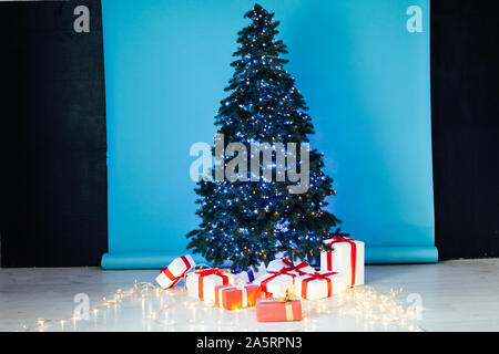 Christmas tree with gifts lights garlands for the new year Stock Photo