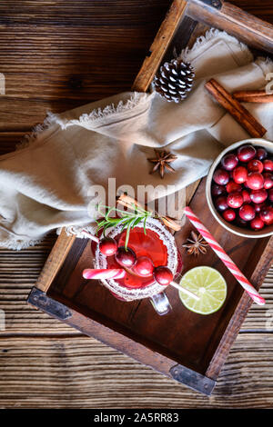 Christmas drink, hot mulled wine with cranberries, lime, star anise and cinnamon on wooden background Stock Photo