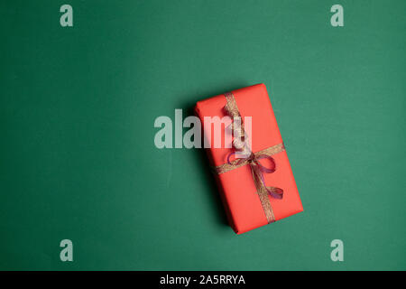 Christmas background with present box, holiday decorations on dark green background. Flat lay style composition, top view. Stock Photo